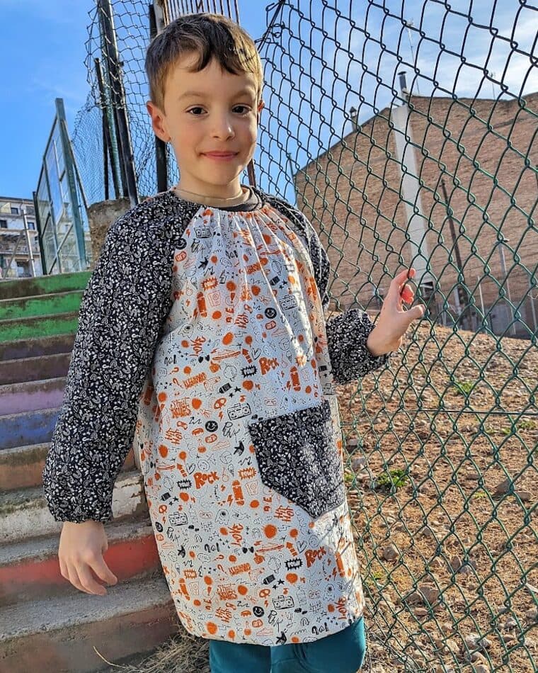 Niño con bata estampada y bolsillo azul