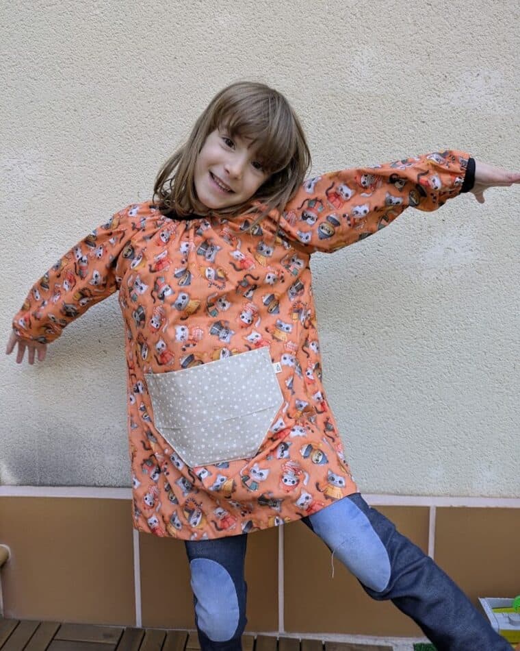 Niña con bata de estampado naranja saltando